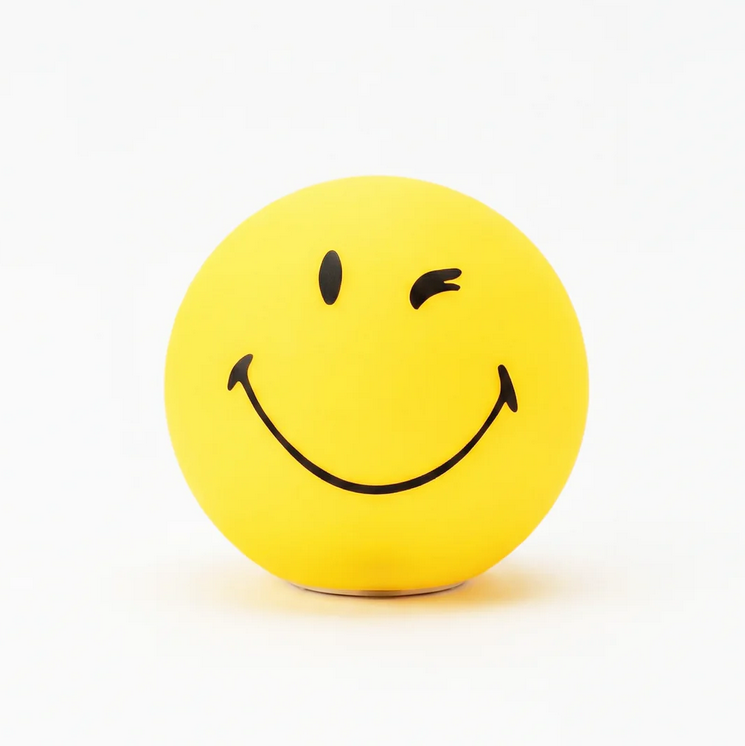 Yellow spherical winking smiley face lamp glowing on white background dopamine decor