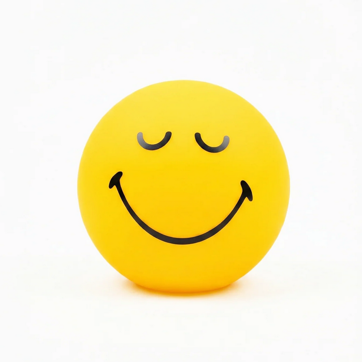 Yellow spherical winking smiley face lamp glowing on white background dopamine decor