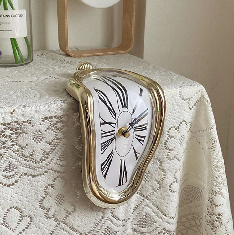 Silver surrealist melting clock resting on the edge of a metal bookshelf next to books