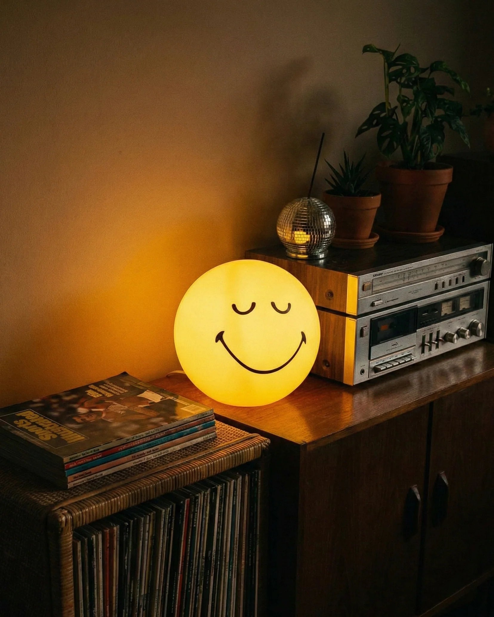 Yellow spherical winking smiley face lamp glowing on white background dopamine decor
