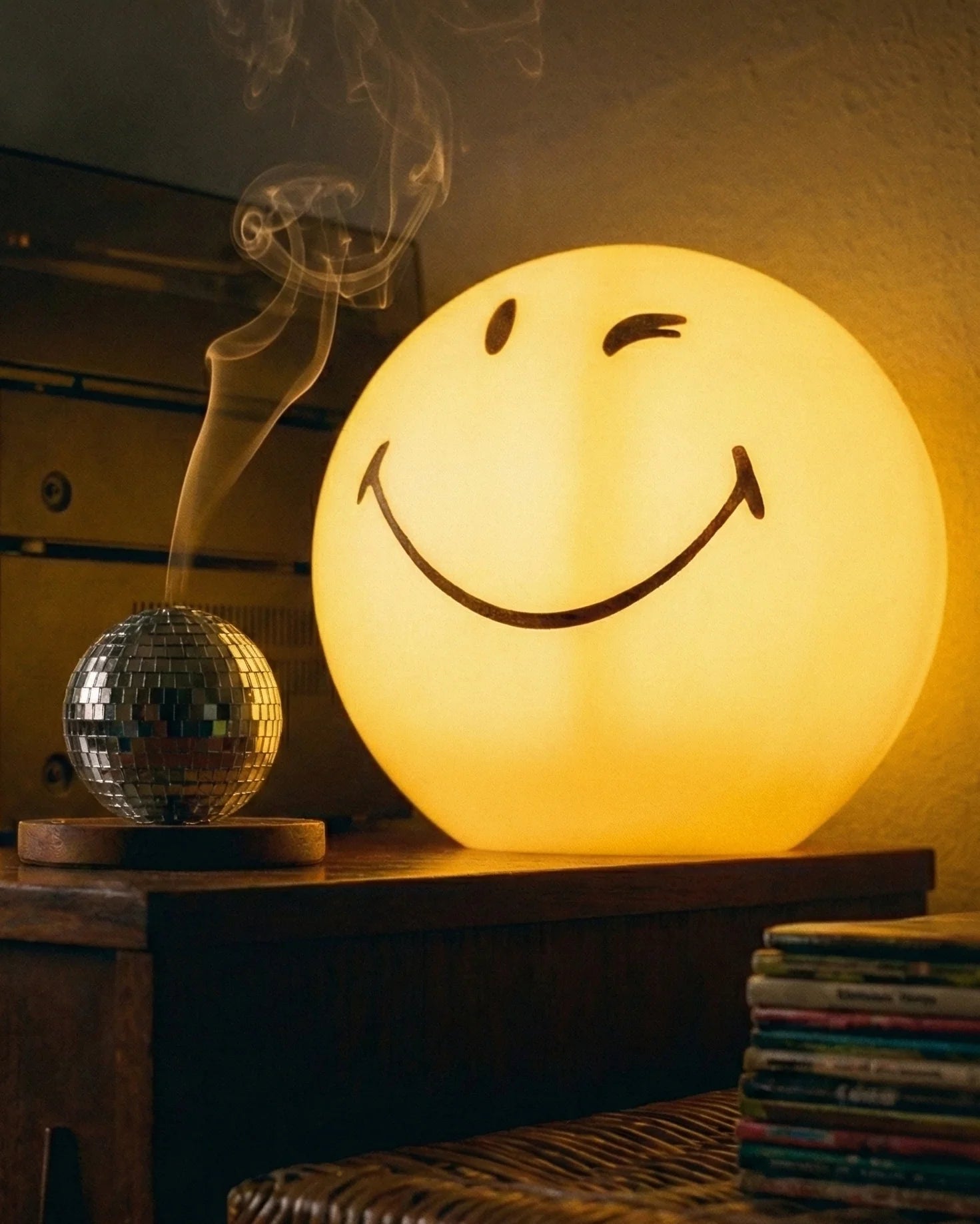 Yellow spherical winking smiley face lamp glowing on white background dopamine decor