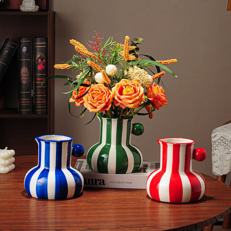 Collection of striped ceramic pitcher vases in green red blue black and yellow with flowers