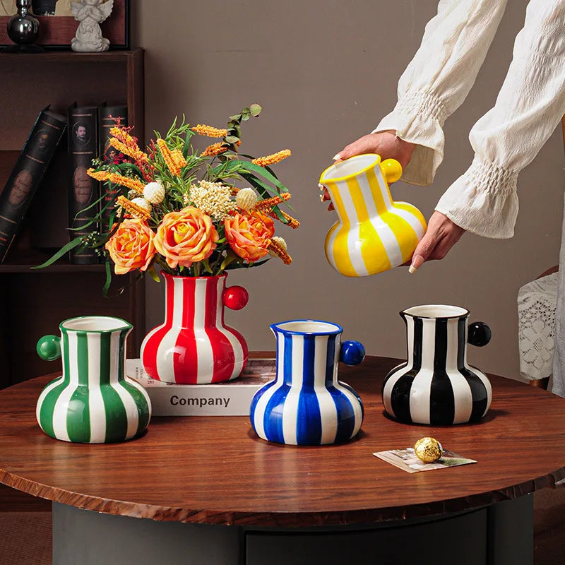 Collection of striped ceramic pitcher vases in green red blue black and yellow with flowers